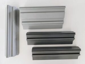 Quattro estrusi di profili Mavis per controtelaio in PVC rigenerato (fino al 100% riciclato) conforme UNI 11979:2025 e CAM
